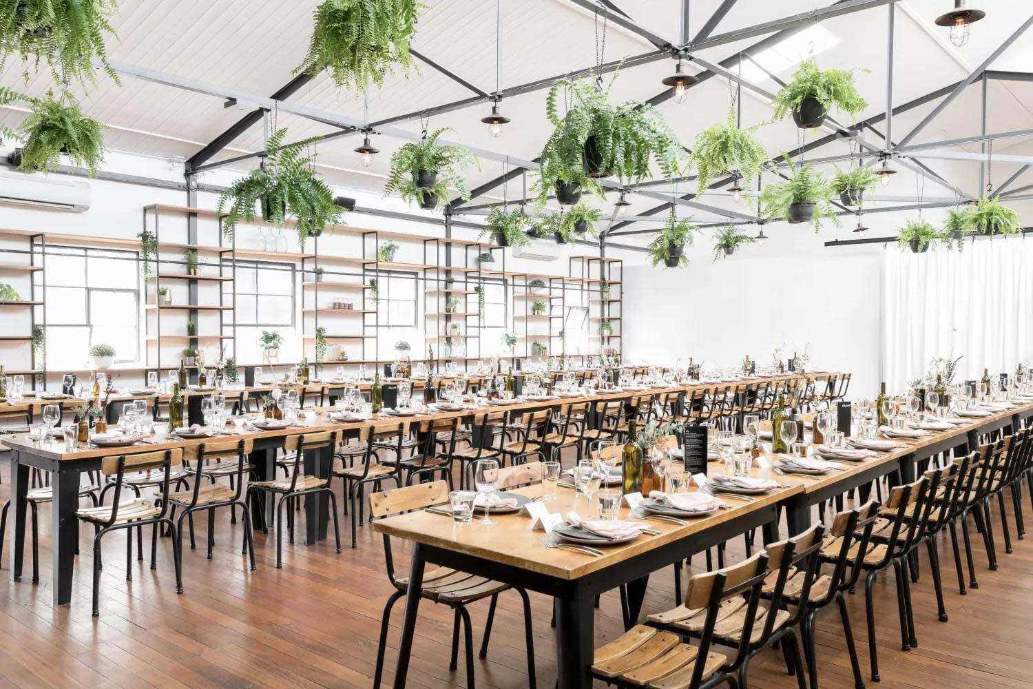 Industrial chic Columbus wedding reception venue with hanging greenery and long tables