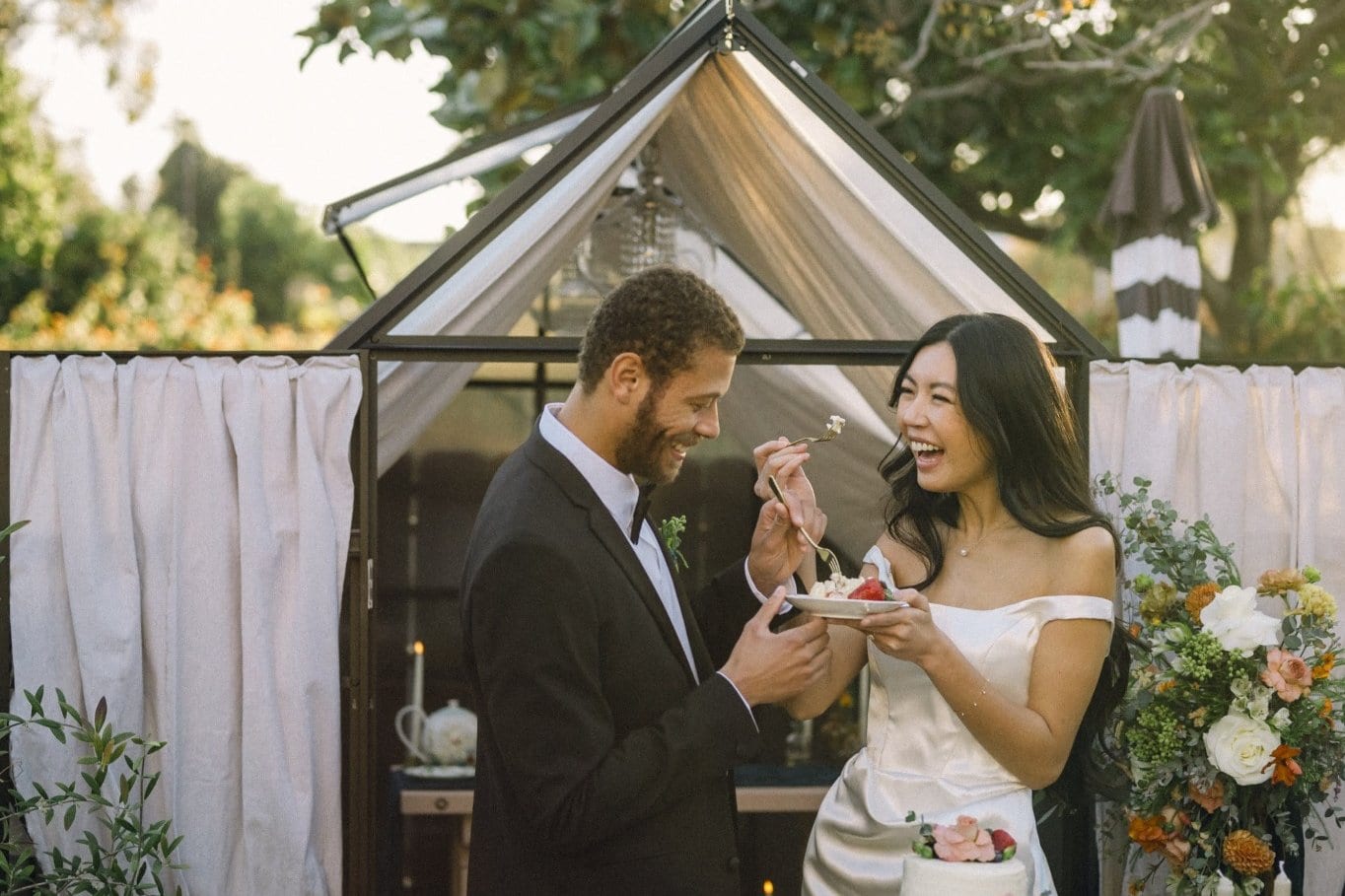 Couple enjoying dessert inside glass garden structure at Jacksonville wedding reception