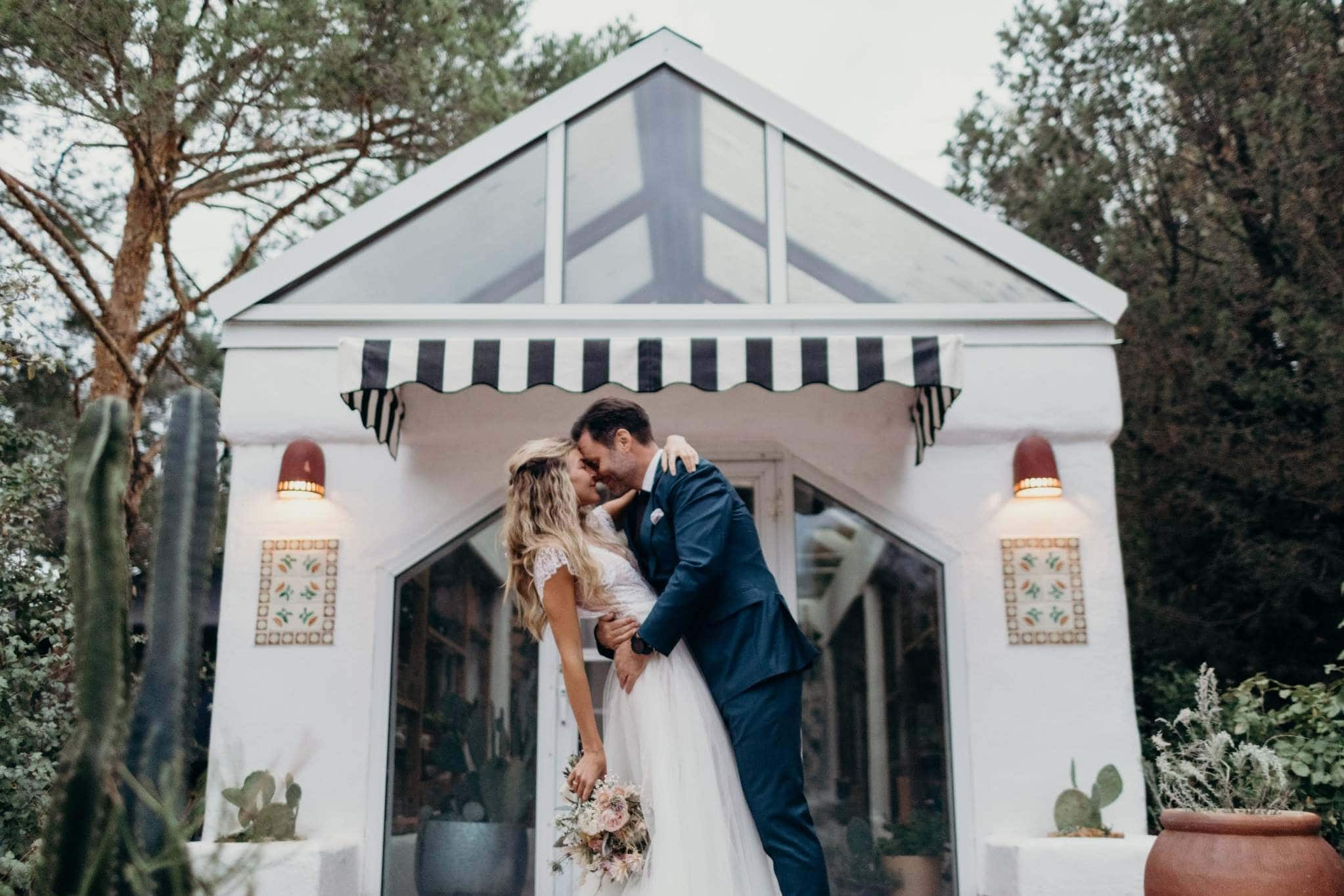 Newlyweds embracing in front of charming white gazebo at Jacksonville wedding