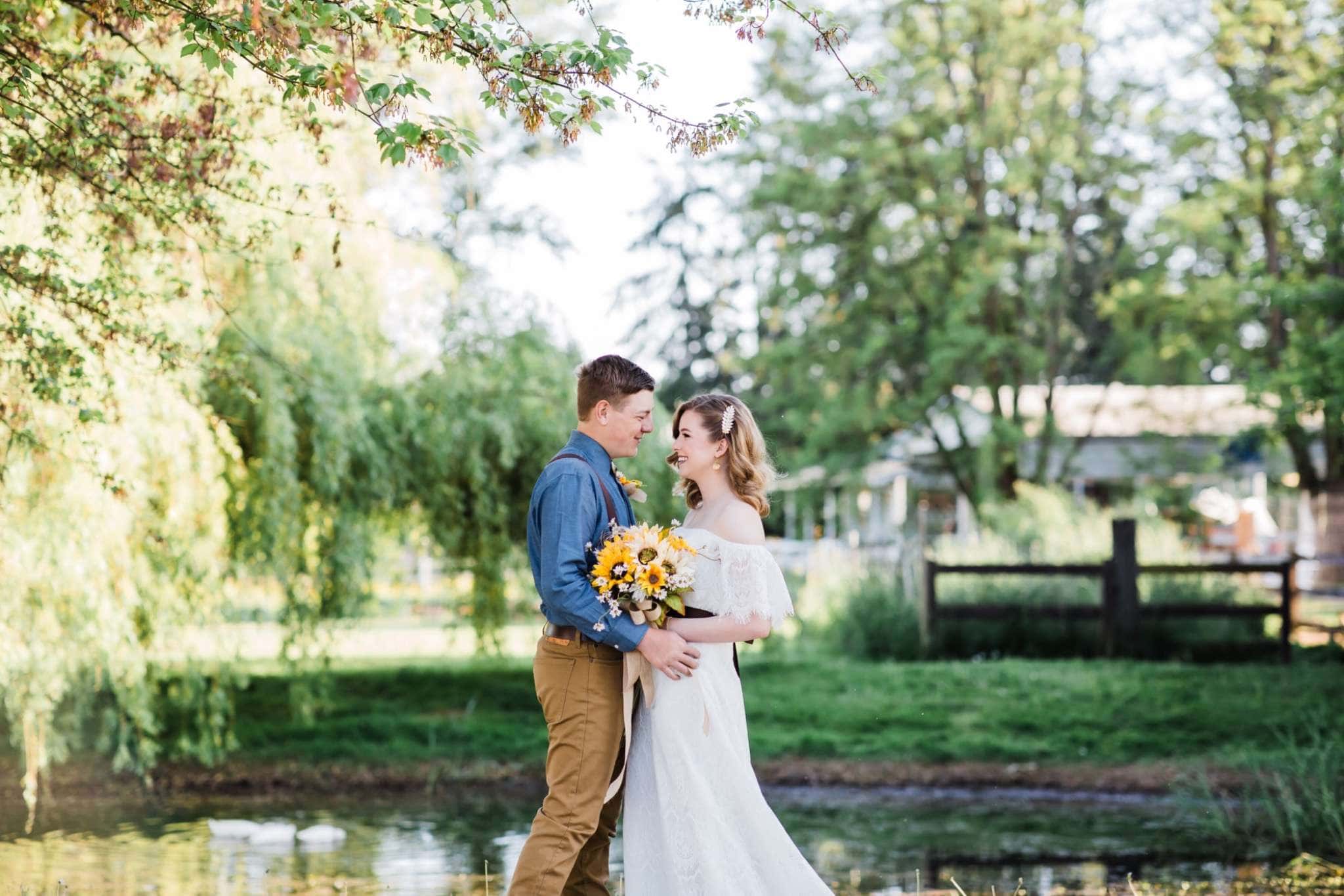 Young couple embracing in lush outdoor Minnesota wedding setting with sunflowers