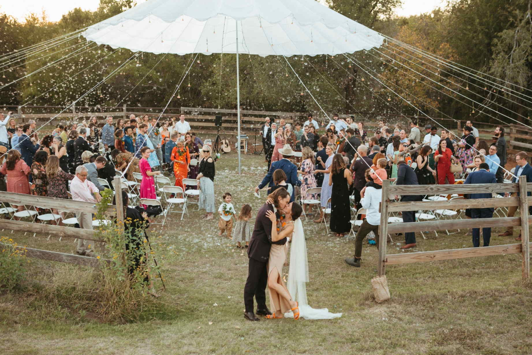 Tented outdoor Oklahoma wedding reception featuring string lights and seated guests