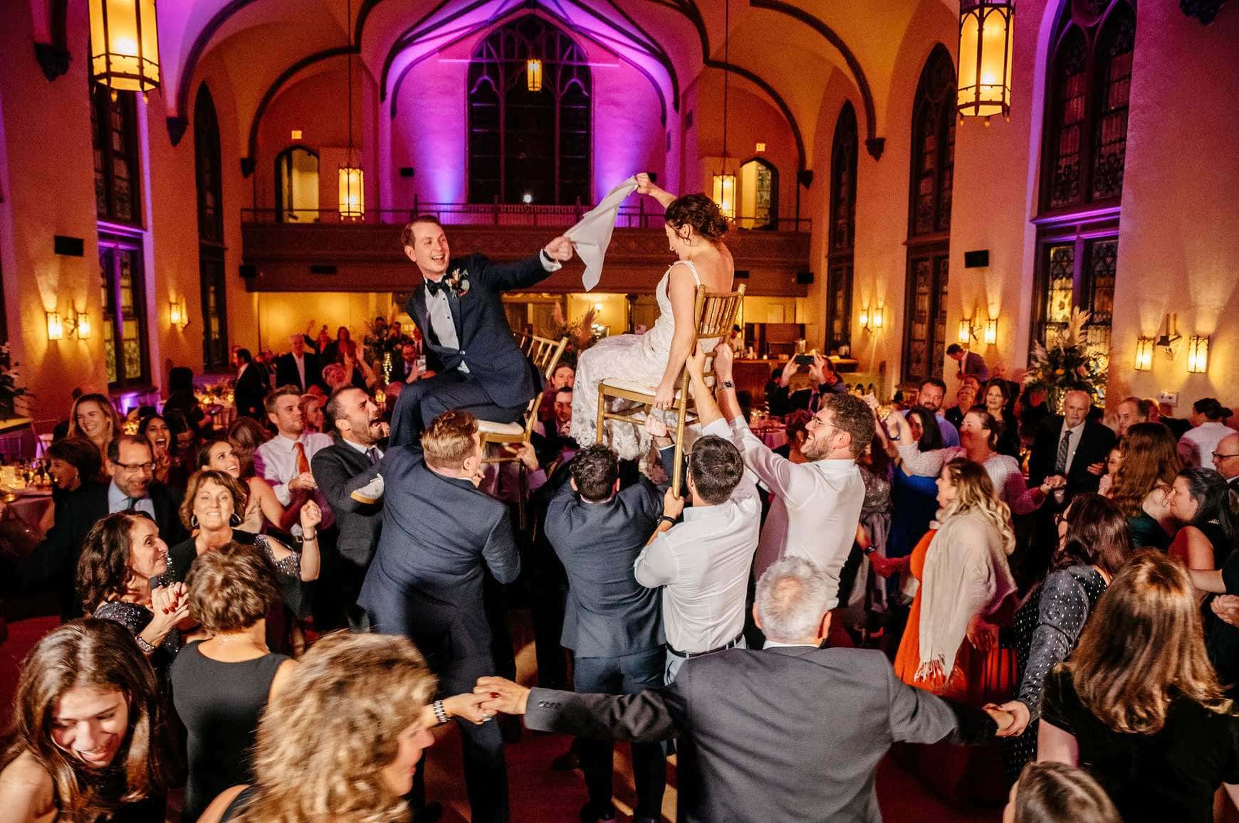 Joyful St. Louis wedding reception with bride lifted in celebration