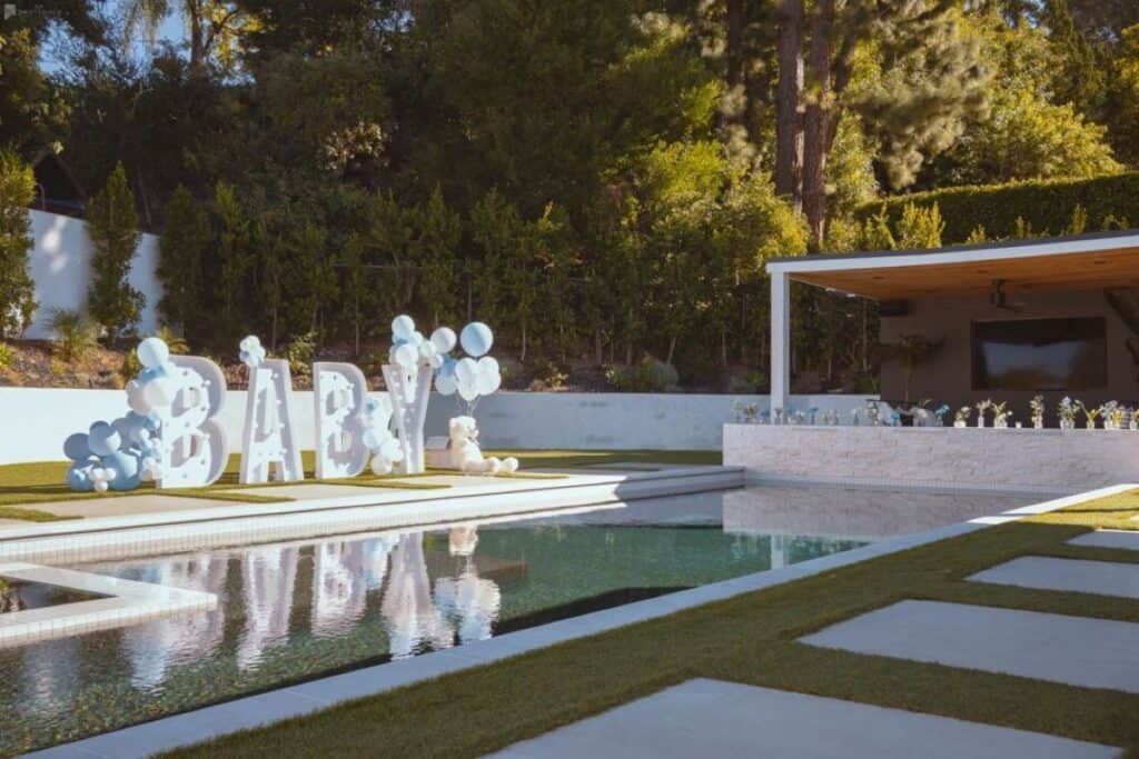 an outdoor baby shower with a pool and balloons