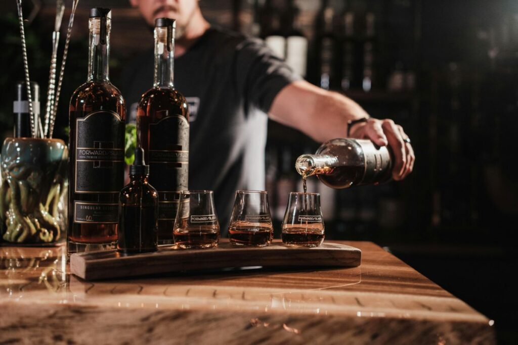 a bartender pouring drinks at a wooden bar