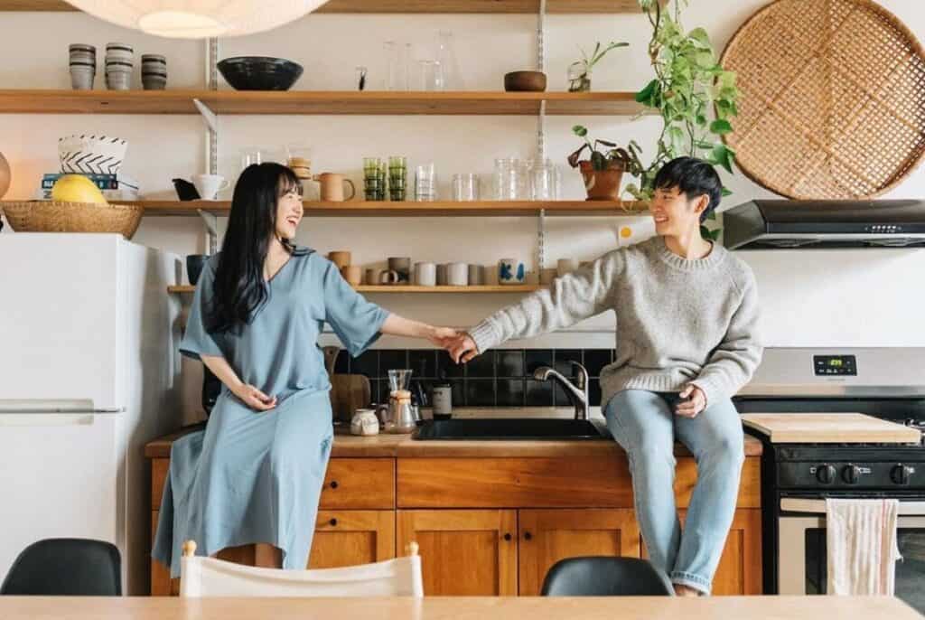 a couple holding hands in a kitchen