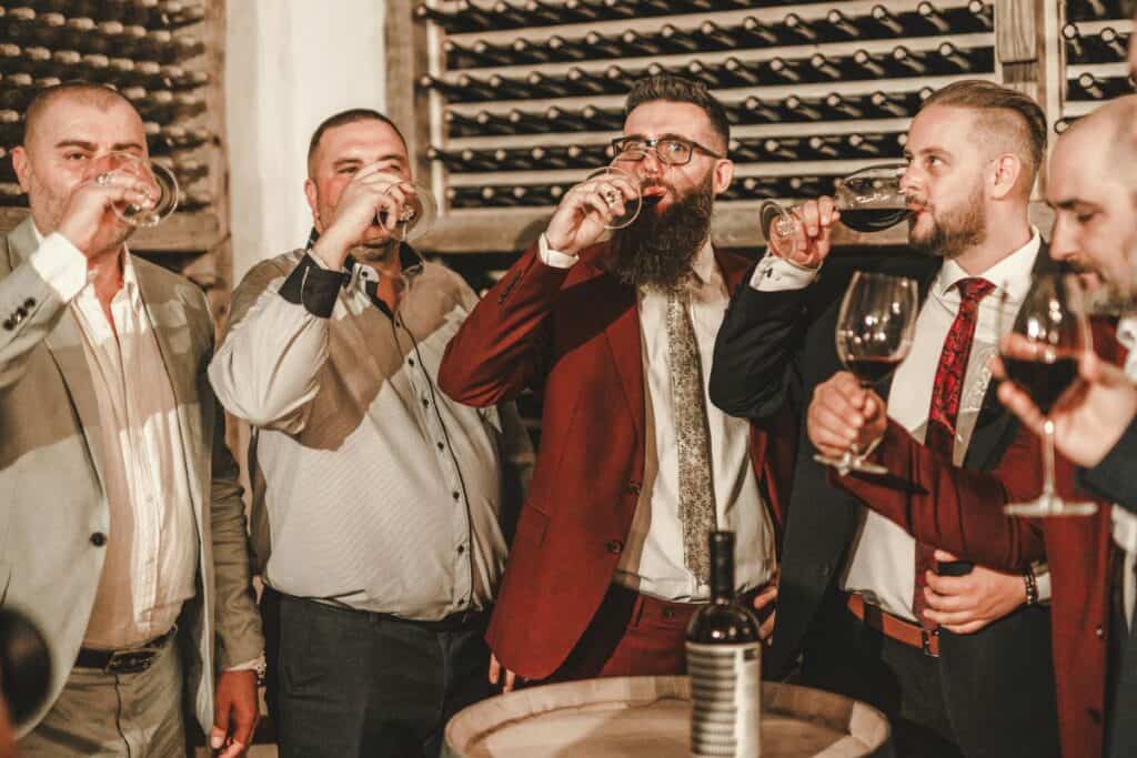 men in suits drinking wine